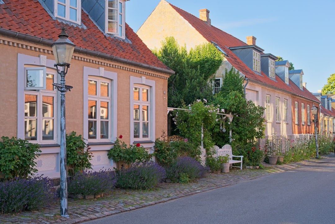 Photographer crouching to photograph a subject in a Danish village