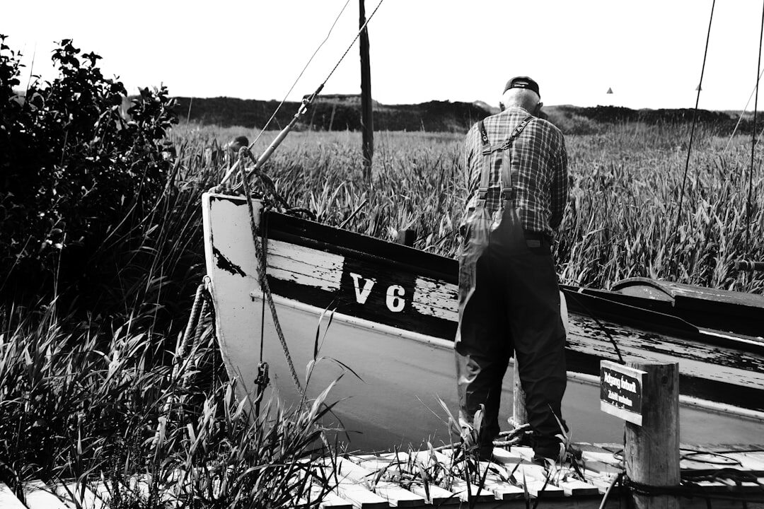 Portrait of an elderly Danish fisherman mending nets on a harbour quay