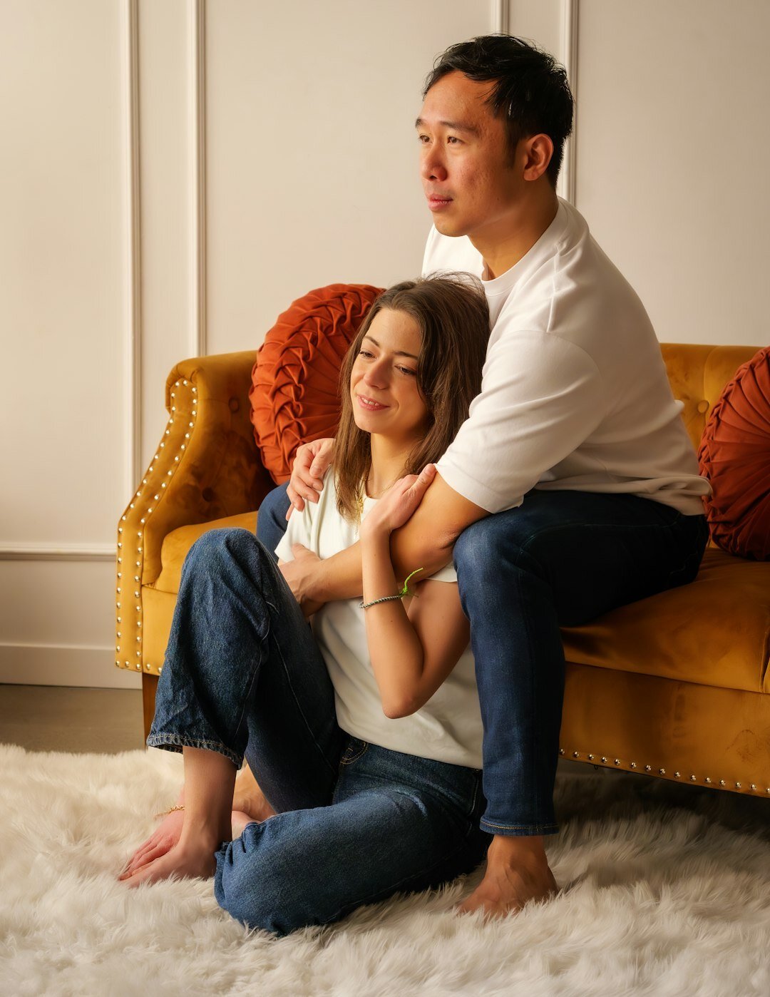 Parents and toddler cuddling on a sofa at home